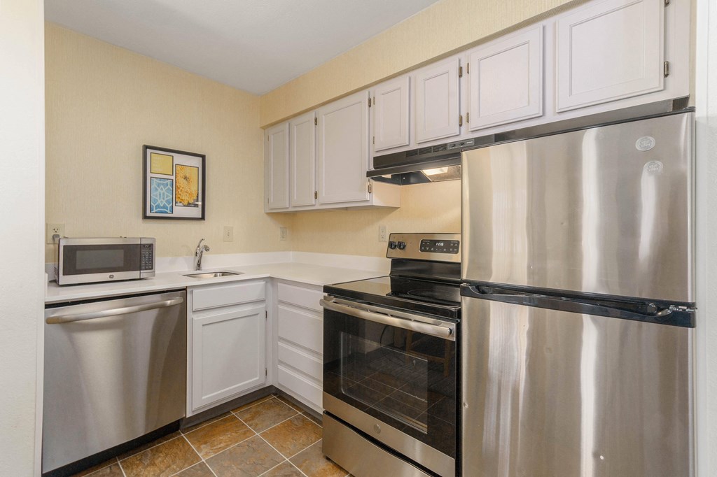 a kitchen with stainless steel appliances and white cabinets